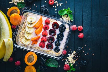 Taze meyveler ve meyve yulaf ezmesi. Sağlıklı bir diyet yemek. Öğle Yemeği boks. Ahşap bir arka plan üzerinde. Üstten Görünüm. Metin için boş alan.