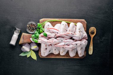 Baharat ile çiğ tavuk kanatları. Ahşap yüzeyde. Üstten Görünüm.