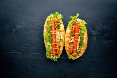 Sosis ızgara sosis, hardal ve ketçap, soğan ve Yeşiller ahşap arka plan üzerinde. Üstten Görünüm. Boş alan.