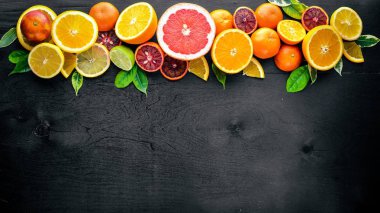 Taze narenciye. Limon portakal, mandalina, limon. Bir siyah arka plan üzerine tahta. Üstten Görünüm.