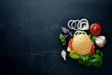 Ahşap arka plan üzerinde peynir, et ve yeşil soğan ile hamburger. Üstten Görünüm. Boş alan.