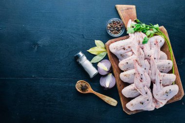 Baharat ile çiğ tavuk kanatları. Ahşap yüzeyde. Üstten Görünüm.