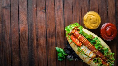 Sosisli otlar ve Baharatlar, hardal ve ketçap. Ahşap arka plan üzerinde. Üst alanı ile ilgilenen.