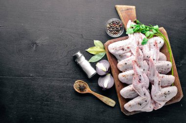 Baharat ile çiğ tavuk kanatları. Ahşap yüzeyde. Üstten Görünüm.