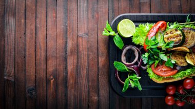 Bruschetta ızgara sebze, zeytin, otlar ve parmesan peyniri ekmeğin. Soğuk aperatifler. İtalyan mutfağı. Ahşap arka plan üzerinde.