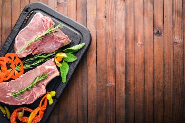 Biftek çiğ et ve baharat ahşap tahta üzerinde. Üstten Görünüm. Boş alan.