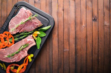 Biftek çiğ et ve baharat ahşap tahta üzerinde. Üstten Görünüm. Boş alan.