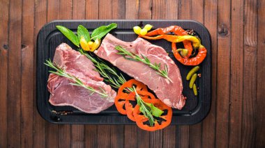 Biftek çiğ et ve baharat ahşap tahta üzerinde. Üstten Görünüm. Boş alan.