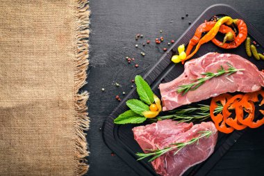 Biftek çiğ et ve baharat ahşap tahta üzerinde. Üstten Görünüm. Boş alan.