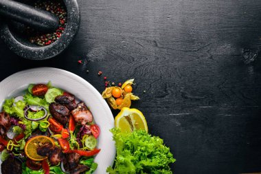 Salata taze salatalık, domates ve yeşillik bir plaka ahşap tahta üzerinde ızgara et ile. Üstten Görünüm. Boş alan.