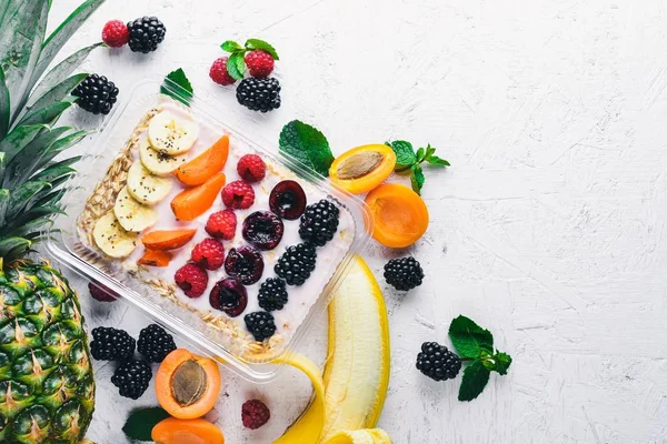 Taze meyveler ve meyve yulaf ezmesi. Sağlıklı bir diyet yemek. Öğle Yemeği boks. Ahşap bir arka plan üzerinde. Üstten Görünüm. Metin için boş alan.