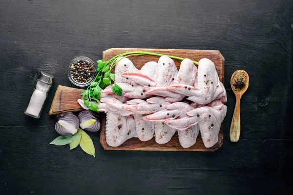 Baharat ile çiğ tavuk kanatları. Ahşap yüzeyde. Üstten Görünüm.