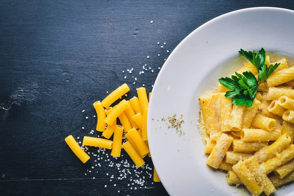 Pasta krema sos ve parmesan peyniri ile. Geleneksel İtalyan yemekleri. Ahşap bir arka plan üzerinde. Üstten Görünüm. Metniniz için boş alan.