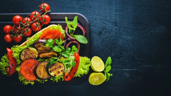 Bruschetta ızgara sebze, zeytin, otlar ve parmesan peyniri ekmeğin. Soğuk aperatifler. İtalyan mutfağı. Ahşap arka plan üzerinde.