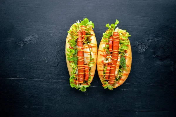 Sosis ızgara sosis, hardal ve ketçap, soğan ve Yeşiller ahşap arka plan üzerinde. Üstten Görünüm. Boş alan.