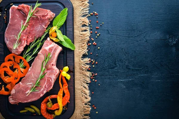 Biftek çiğ et ve baharat ahşap tahta üzerinde. Üstten Görünüm. Boş alan.