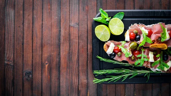 Bruschetta et, zeytin, otlar ve parmesan Peynirli ekmek. Soğuk aperatifler. İtalyan mutfağı. Ahşap arka plan üzerinde.