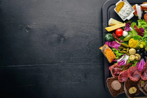 Um grande conjunto de cozinha italiana. Queijo, salsicha, carne e legumes em conserva na tábua de madeira. Vista superior. Espaço livre . — Fotografia de Stock