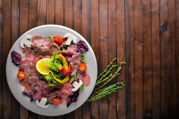 Carpaccio sığır eti, sebze, peynir, baharatlar, ahşap arka plan için. Üstten Görünüm. Boş alan