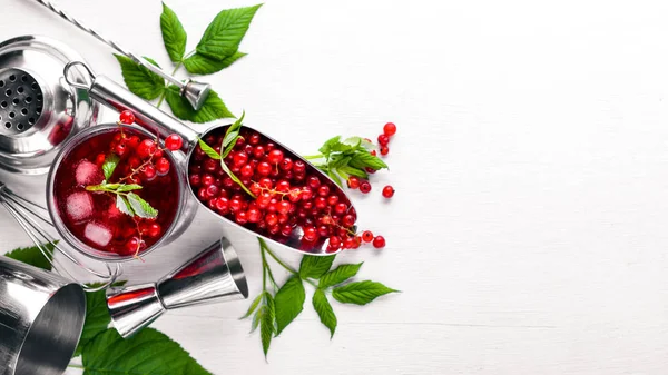 Ahşap arka plan üzerinde buz ile taze kırmızı kuş üzümü kokteyl. Üstten Görünüm. Boş alan.