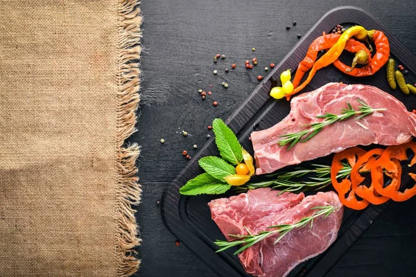 Biftek çiğ et ve baharat ahşap tahta üzerinde. Üstten Görünüm. Boş alan.