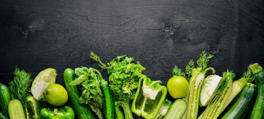 Büyük bir set bir ahşap zemin üzerine yeşil sebze. Üstten Görünüm. Boş alan.