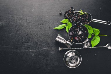 Ahşap arka plan üzerinde buz ile taze Siyah frenk üzümü kokteyl. Üstten Görünüm. Boş alan.