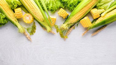 Mısır. Çiğ sebze siyah bir ahşap zemin üzerine. Üstten Görünüm. Metniniz için boş alan.