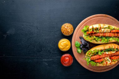 Sosis ızgara sosis, hardal ve ketçap, soğan ve Yeşiller ahşap arka plan üzerinde. Üstten Görünüm. Boş alan.