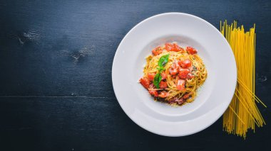 Makarna domates. Geleneksel İtalyan yemekleri. Ahşap bir arka plan üzerinde. Üstten Görünüm. Metniniz için boş alan.