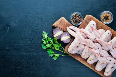 Baharat ile çiğ tavuk kanatları. Ahşap yüzeyde. Üstten Görünüm.