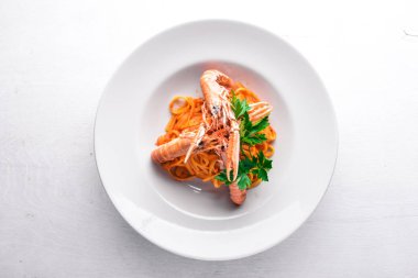 Domates soslu makarna ve kaplan karides. Geleneksel İtalyan yemekleri. Ahşap bir arka plan üzerinde. Üstten Görünüm. Metniniz için boş alan.