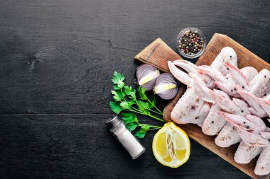 Baharat ile çiğ tavuk kanatları. Ahşap yüzeyde. Üstten Görünüm.