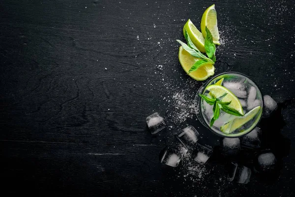 Lime och Mint cocktail, med is, på en yta av svart trä. Ovanifrån. Ledigt utrymme. — Stockfoto