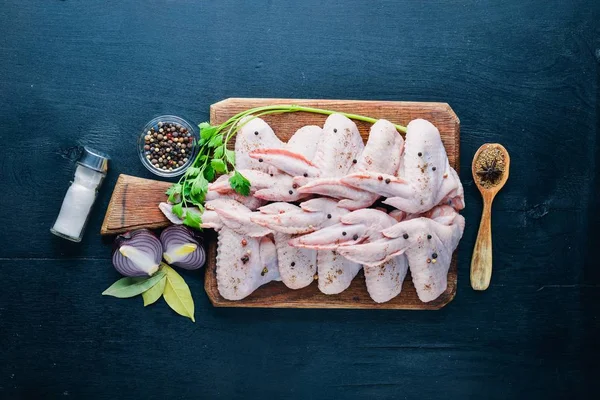 Baharat ile çiğ tavuk kanatları. Ahşap yüzeyde. Üstten Görünüm.