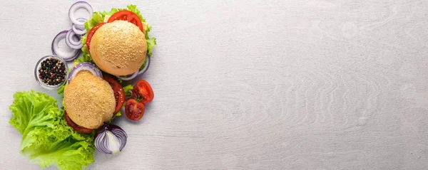 Peynir, et, domates ve soğan ve otlar ile hamburger. Ahşap arka plan üzerinde. Üstten Görünüm. Boş alan.
