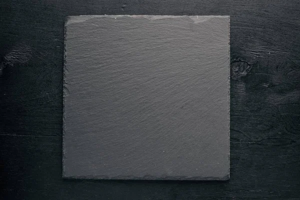 Kara taş tahta. Ahşap bir arka plan üzerinde. En iyi bir daha gözden geçirme. Boş alan.