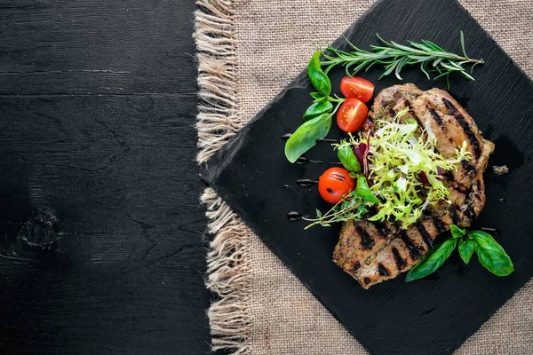 Dana biftek ızgarada pişirilir. Ahşap bir arka plan üzerinde. En iyi bir daha gözden geçirme. Boş alan.