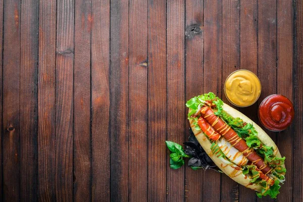 Sosisli otlar ve Baharatlar, hardal ve ketçap. Ahşap arka plan üzerinde. Üst alanı ile ilgilenen.