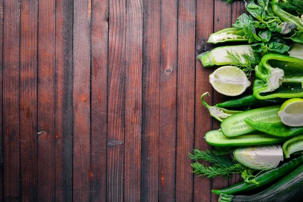 Büyük bir set bir ahşap zemin üzerine yeşil sebze. Üstten Görünüm. Boş alan.