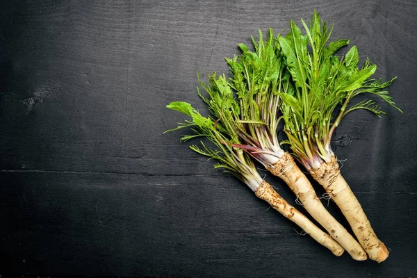 Taze horseradish. Siyah ahşap masanın üzerinde. Üstten Görünüm.
