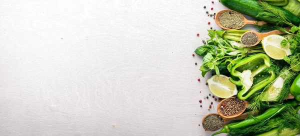 Yeşil sebzeler ve baharat ahşap arka plan üzerinde büyük bir seçim. Üstten Görünüm. Boş alan.