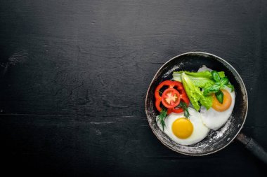 Sahanda yumurta ile bir tavada sebze ve otlar. Üstten Görünüm. Boş alan.