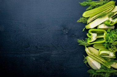 Büyük bir set bir ahşap zemin üzerine yeşil sebze. Üstten Görünüm. Boş alan.