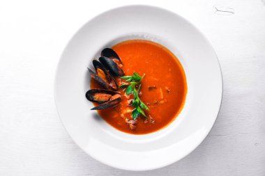Tomato and seafood creamy soup with mussels. On a wooden background. Top view. Free space for your text. clipart