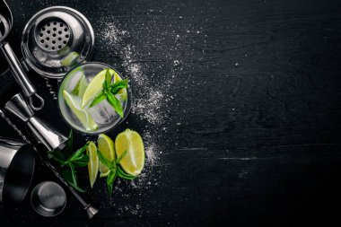Limon ve nane kokteyli, buz, siyah ahşap yüzeye. Üstten Görünüm. Boş alan.