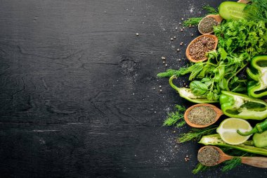 Yeşil sebzeler ve baharat ahşap arka plan üzerinde büyük bir seçim. Üstten Görünüm. Boş alan.