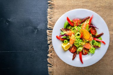 Salata somon ve taze sebze ve otlar. İtalyan mutfağı. Üstten Görünüm. Ahşap arka plan üzerinde.