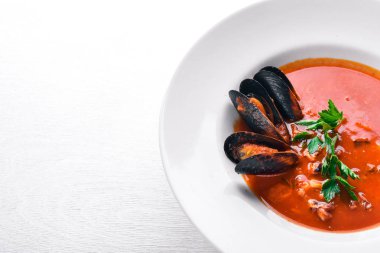 Tomato and seafood creamy soup with mussels. On a wooden background. Top view. Free space for your text. clipart