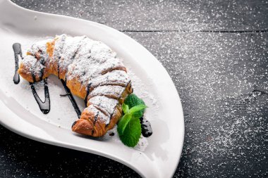 Kruvasan. Ahşap bir arka plan üzerinde. Üstten Görünüm. Metniniz için boş alan.